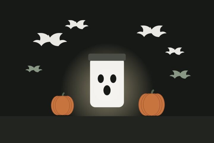 Illustration of paper bats flying over a glowing jar lantern with a ghost face